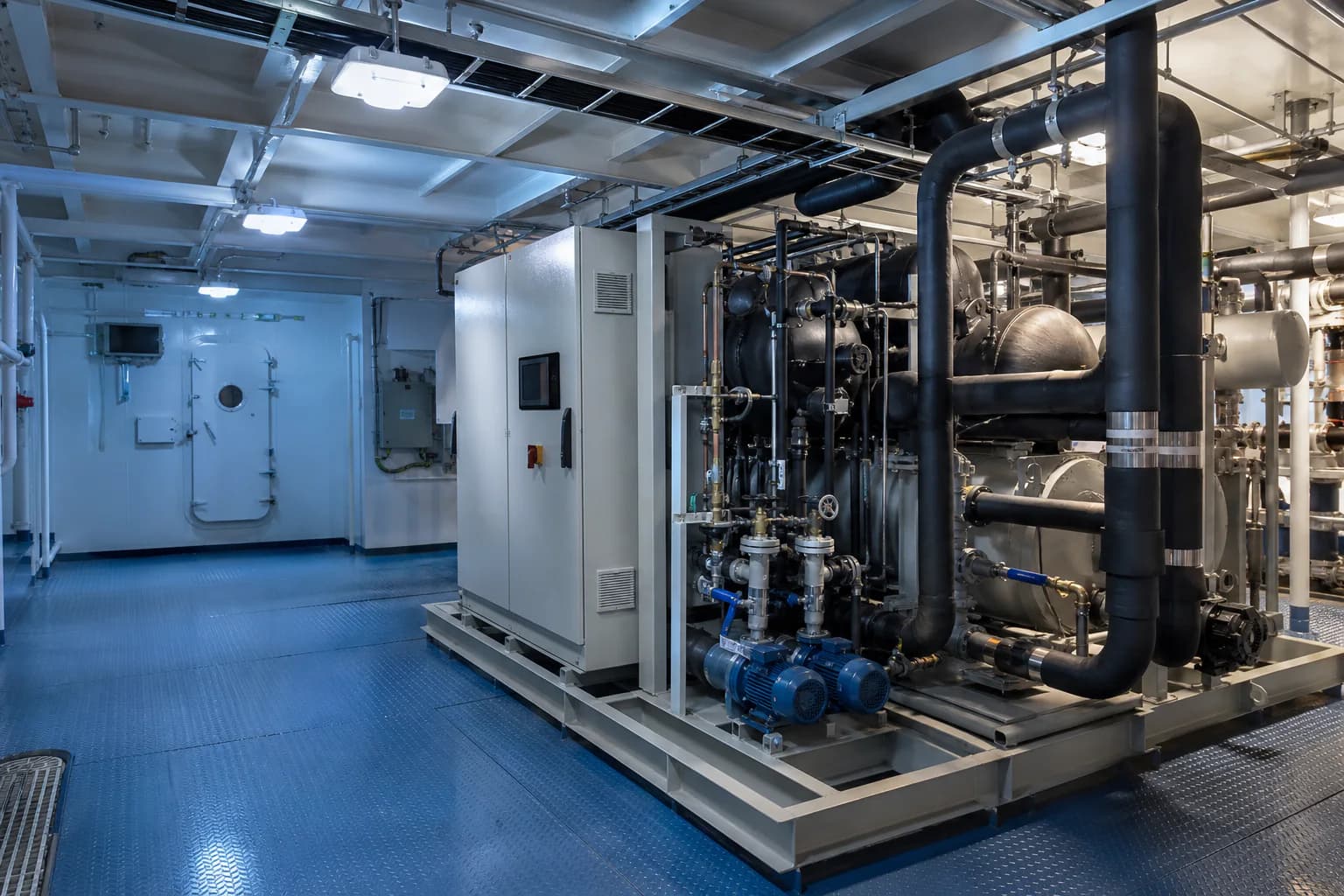Unbranded central marine chiller installation with insulated chilled-water piping in a commercial vessel machinery space