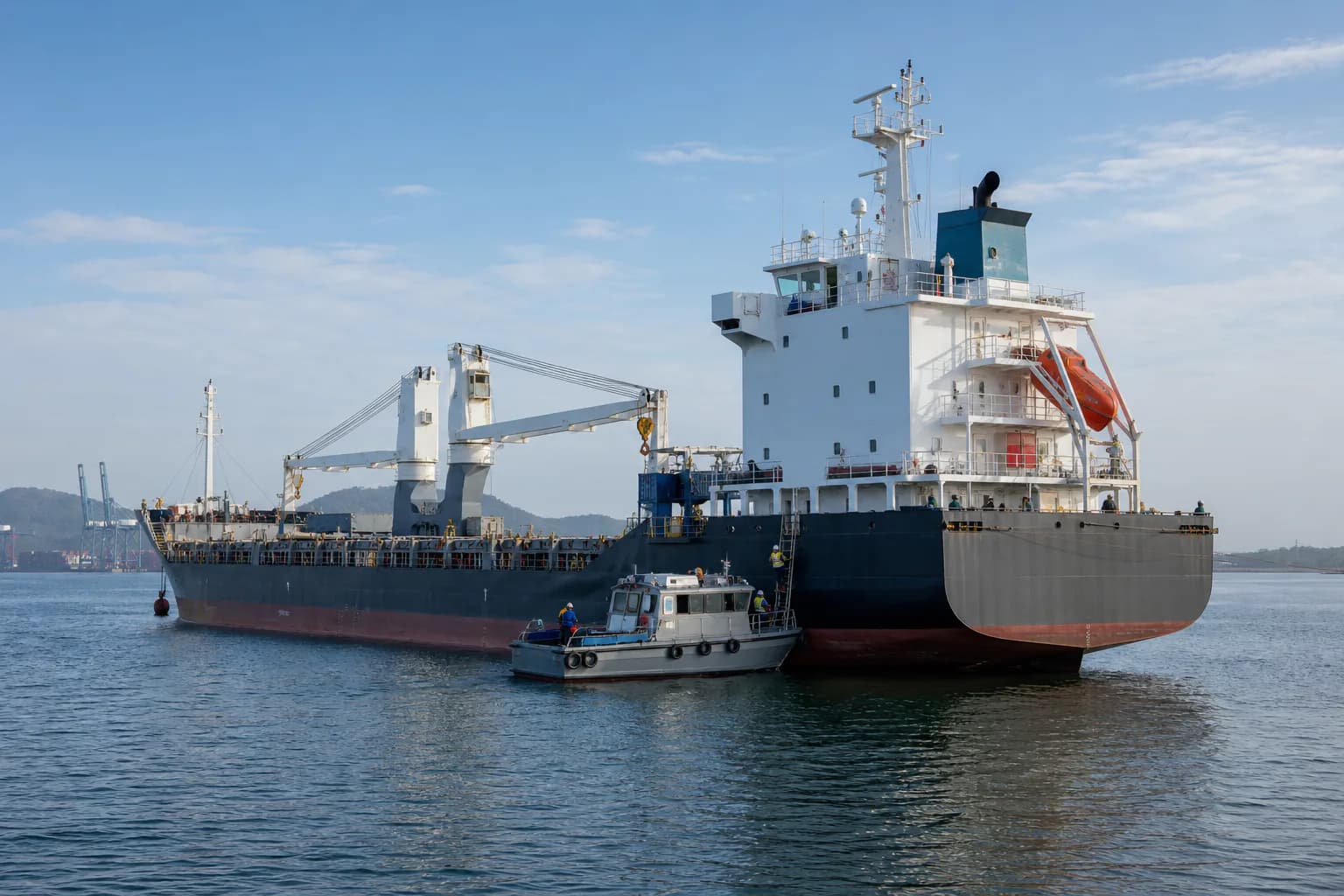 Marine technical team mobilizing from a service launch alongside a commercial vessel afloat