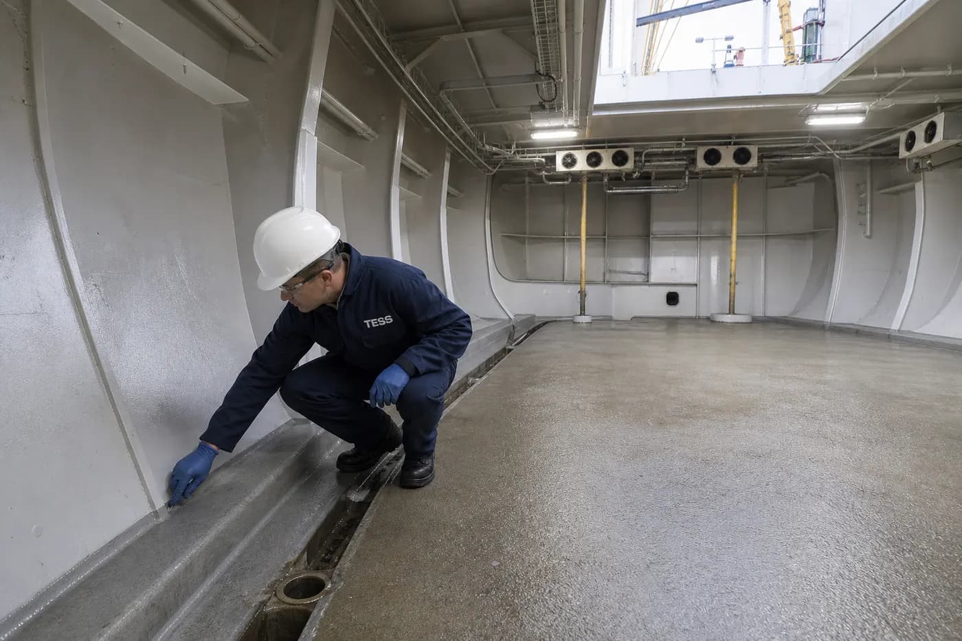 Technician inspecting the insulated fish hold of a commercial fishing vessel